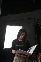 mulher asiática da Indonésia lendo um livro contra um fundo claro foto