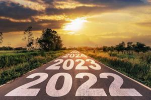 conceito de objetivos do ano novo 2022 estrada de asfalto vazia nascer do sol com texto ir para o ano novo 2022 foto