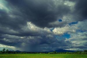 nuvens de tempestade no campo de arroz na estação chuvosa foto