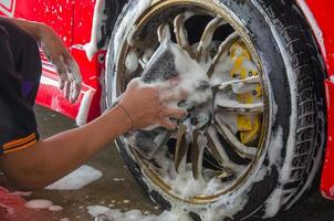 lavando os pneus de um carro vermelho foto