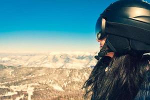 lado Visão fêmea caucasiano esquiador sorrir apreciar Nevado Cáucaso montanhas fundo em topo ponto de vista dentro Bakuriani esqui recorrer.. esqui feriado dentro Cáucaso montanhas foto