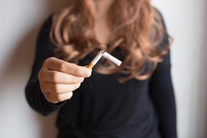 Pare de fumar. o conceito de mulheres segurando um cigarro nas mãos. mulheres felizes que param de fumar, abandonam os maus hábitos, conceitos de saúde, não fumam, concentram as mãos. foto