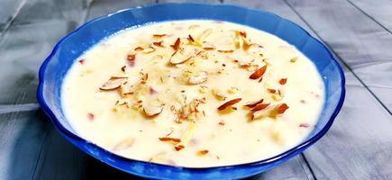 doce rabdi ou lachha rabri ou basundi, feito com leite puro guarnecido com frutas secas. servido em uma tigela sobre fundo temperamental. foto