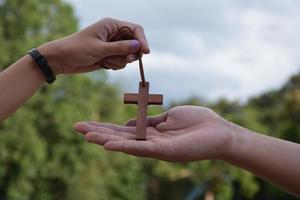 jovens cristãos asiáticos mostram e dão colar com uma cruz para outras pessoas, foco suave e seletivo, conceito para mostrar orgulho em ser cristão para outras pessoas ao redor do mundo. foto