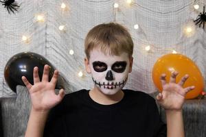 retrato de um menino com maquiagem no rosto em forma de esqueleto para halloween foto