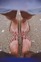 pés de jovem amante na praia foto