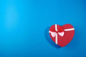 um cartão postal de uma caixa em forma de coração e rosebuds.valentine's day concept foto
