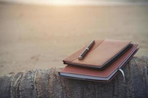 um caderno e caneta na praia foto