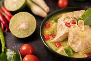 prato de curry verde com frango, pimenta e manjericão e tomate e limão foto