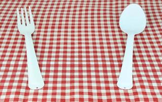 garfo e colher brancos na toalha de mesa foto