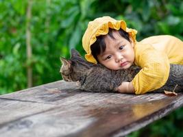 bebê asiático de nacionalidade tailandesa e gato no de mala cafe, thung saliam, sukhothai, tailândia. foto