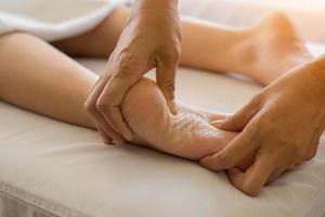 close-up de mulher fazendo massagem nos pés no spa foto
