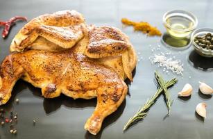 frango grelhado com ingredientes no fundo escuro de madeira foto