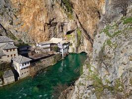 vista aérea do drone de tekija em blagaj em bih. a tekija, casa dos dervixes, situada na nascente do rio buna, era e ainda é um local para o canto de louvor dos dervixes zikr três noites por semana. foto