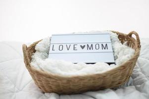 cesto de madeira com tecido e placa da mãe do amor foto