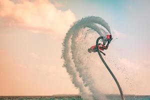 piloto profissional de fly board no mar tropical, fundo do conceito de esportes aquáticos. férias de verão diversão ao ar livre esporte e recreação foto