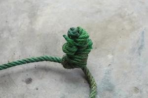 verde atado corda isolado com esbranquiçado cinzento parede foto