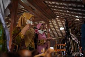 visitantes olhando para uma coleção de kerises em uma galeria. bantul, Indonésia - 25 de agosto de 2022 foto
