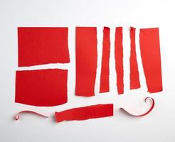 vários rasgado tiras do vermelho papel em uma branco fundo, foto