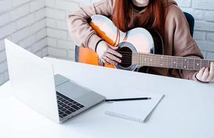 jovem mulher Aprendendo para jogar guitarra às casa foto