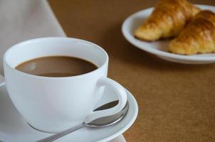 xícara de café e croissant no café da manhã foto