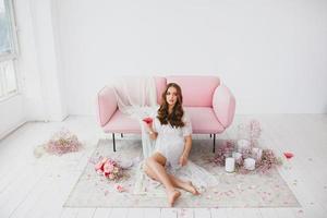 jovem noiva dentro branco lingerie posando perto a rosa sofá dentro a estúdio foto