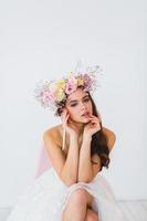 retrato do lindo noiva com flor guirlanda em dela cabeça às branco fundo foto