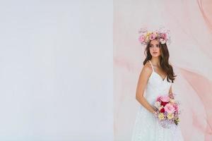 jovem noiva dentro branco vestir com flor guirlanda em dela cabeça posando dentro a estúdio foto