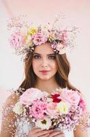 retrato do lindo noiva com flor guirlanda em dela cabeça e nupcial ramalhete foto
