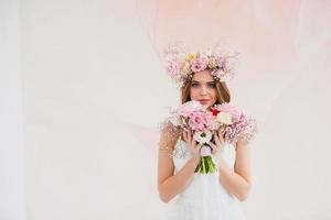 retrato do lindo noiva com flor guirlanda em dela cabeça e nupcial ramalhete foto