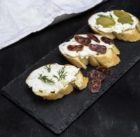 sanduíches com queijo branco cremoso, linguiça, azeitonas e endro foto