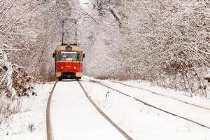 um velho bonde se movendo por uma floresta de inverno foto