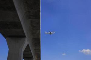 avião comercial sobrevoando em um trilho de transporte ferroviário foto