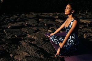 menina medita dentro natureza senta com fechadas olhos em pedras