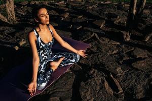 menina medita dentro natureza senta com fechadas olhos em pedras Visão a partir de acima