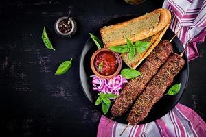 Kebab adana, Cordeiro e carne e Torradas com pesto molho. topo Visão foto