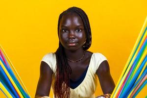 bonita jovem africano adolescente é jogando com grandes colorida bebendo palhas foto