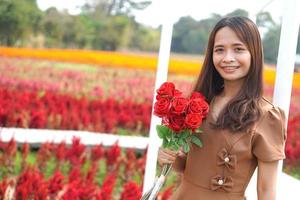 ásia mulher sorridente alegremente entre lindo flores foto