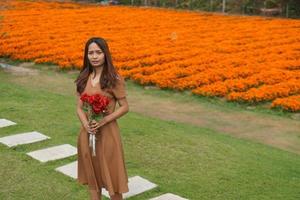 ásia mulher sorridente alegremente entre lindo flores foto