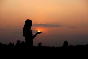 silhueta do humano mão elevado para faço uma desejar, pôr do sol fundo foto