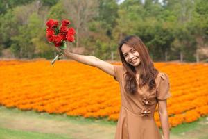 ásia mulher sorridente alegremente entre lindo flores foto