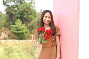 ásia mulher sorridente alegremente entre lindo flores foto