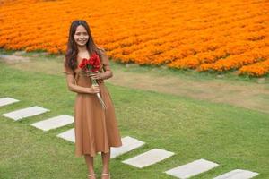 ásia mulher sorridente alegremente entre lindo flores foto