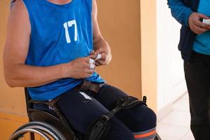 um jogador de basquete com deficiência se prepara para uma partida sentado em uma cadeira de rodas. preparativos para uma partida de basquete profissional. o conceito de esporte para deficientes foto