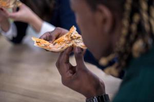 equipe de negócios multiétnica comendo pizza foto