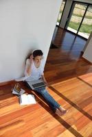 jovem relaxada em casa trabalhando no laptop foto