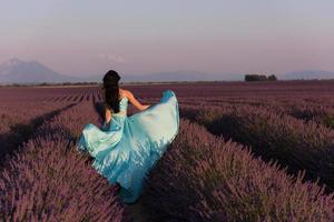 mulher no campo de flores de lavanda foto