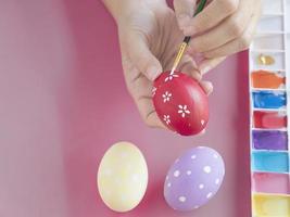 pessoas pintando ovos de páscoa coloridos - conceito de celebração do feriado de páscoa foto