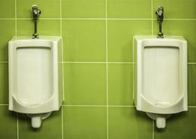 urinóis em uma parede verde foto