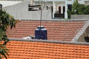 oeste Jacarta, Indonésia - fevereiro 10º, 2023 - azul água tanque em casa cobertura topo com edifícios fundo isolado em retângulo modelo. foto